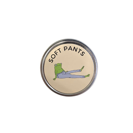 Metal candle lid with an illustration of a smiling frog wearing sweatpants and text "Soft Pants"
