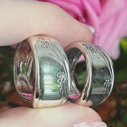 Thick silver rings made from spoons with flower etchings on the outside.