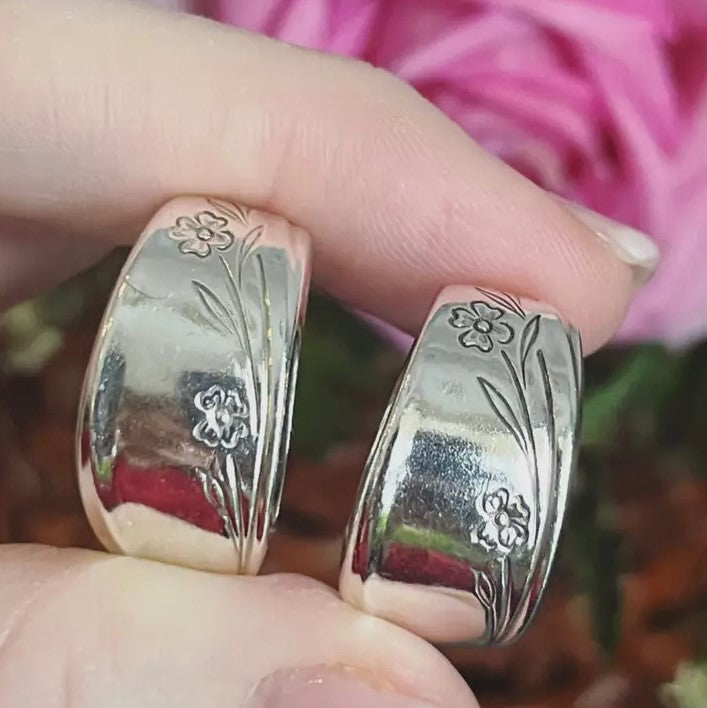 Thick silver rings made from spoons with flower etchings on the outside.