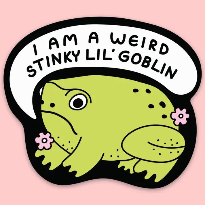 A vinyl sticker depicting a cartoon frog with a speech bubble saying "I am a weird stinky lil' goblin."