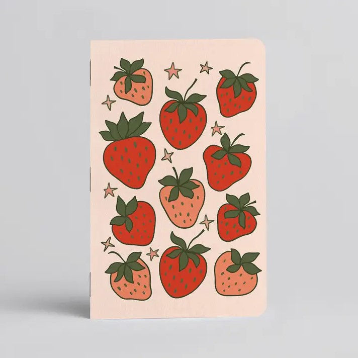 Cream color notebook with cartoon strawberries on the front