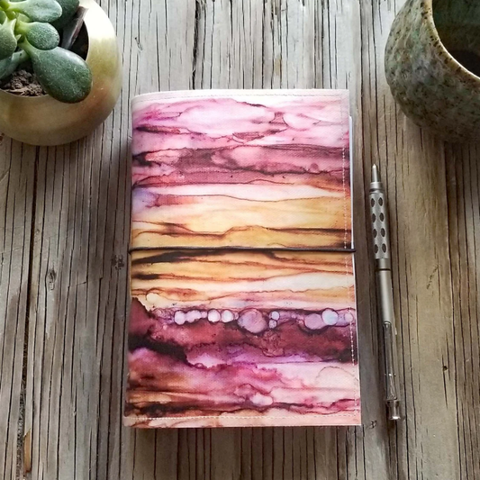 watercolor red and orange waves creating a sunset on a journal