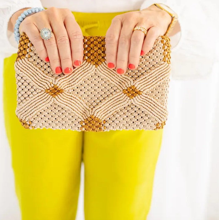 A macrame clutch purse in beige and gold colors.