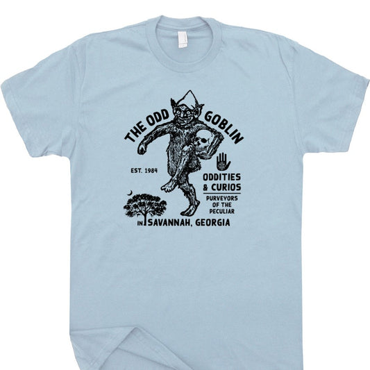 Light blue tee shirt with a graphic of a skipping goblin and text that reads "The Odd Goblin Oddities and Curios"