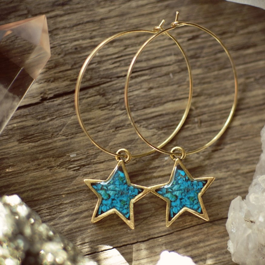stars filled with turqouise gemstones on a gold hoop earrings