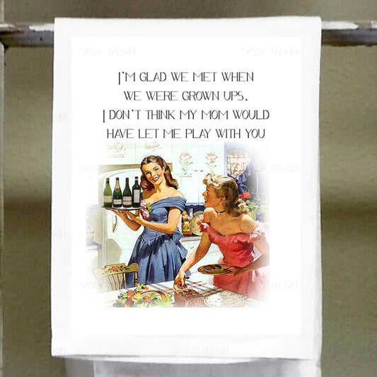White tea towel with a vintage-style illustration of two women in the kitchen with four wine bottles and text that reads "I'm glad we met when we were grown ups. I don't think my mom would let me play with you"