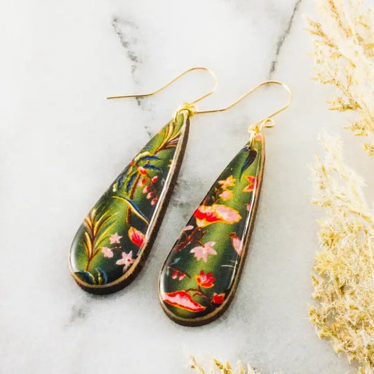 Teardrop-shaped green dangle earrings with a pink and red floral pattern on them