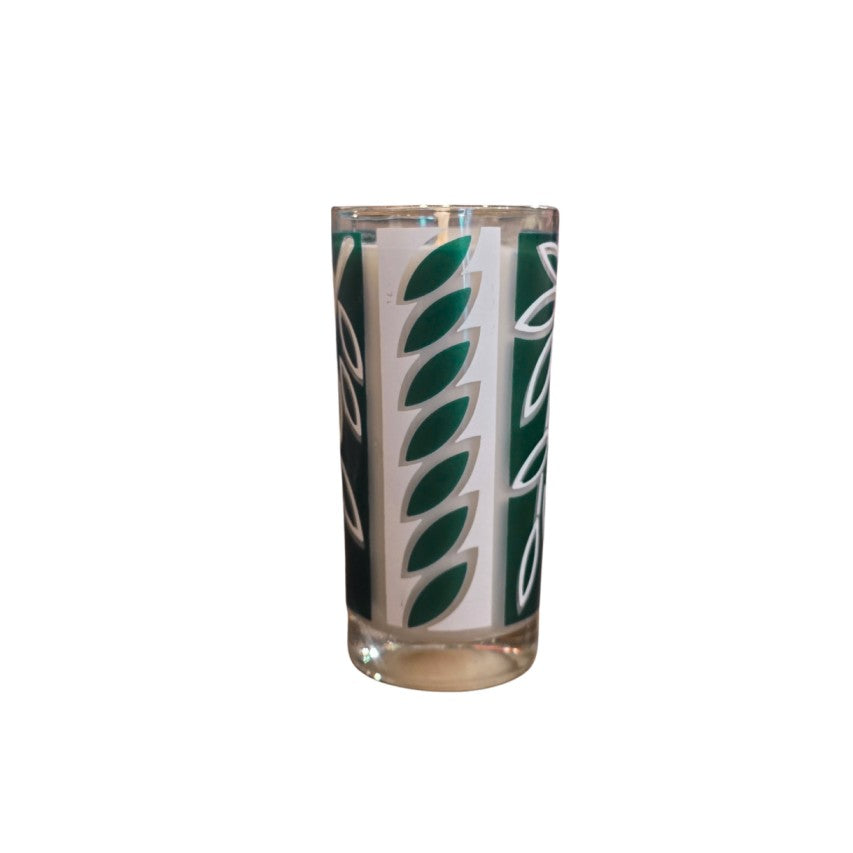 Candle in a white and green patterned glass