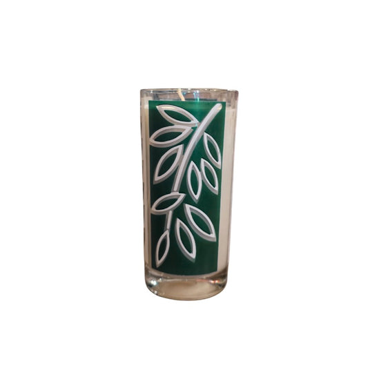 Candle in a glass with a green and white leaf pattern