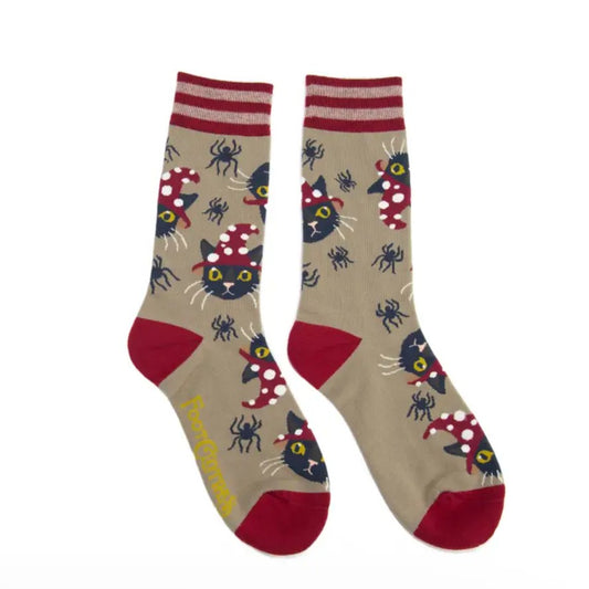 Pair of beige calf socks patterned with black cats wearing red polka dotted witch hats