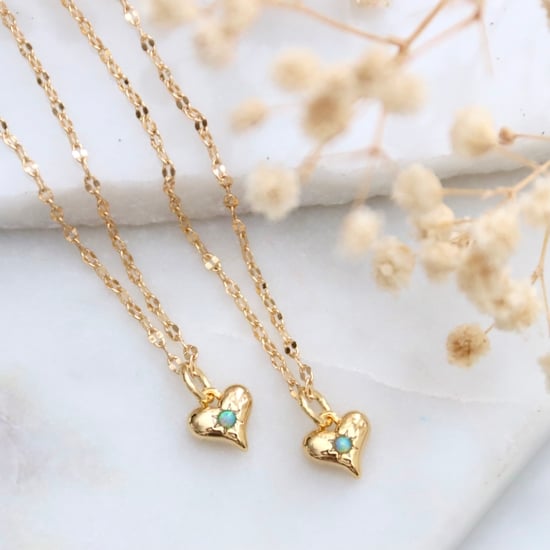 opal in the middle of a gold heart on a dainty chain