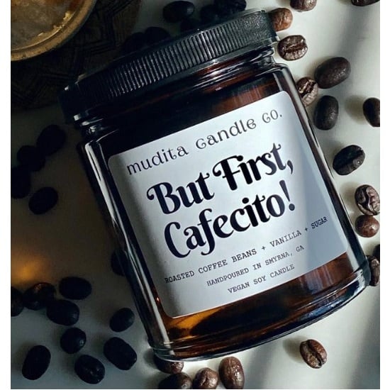 Brown candle with white label laid on coffee beans