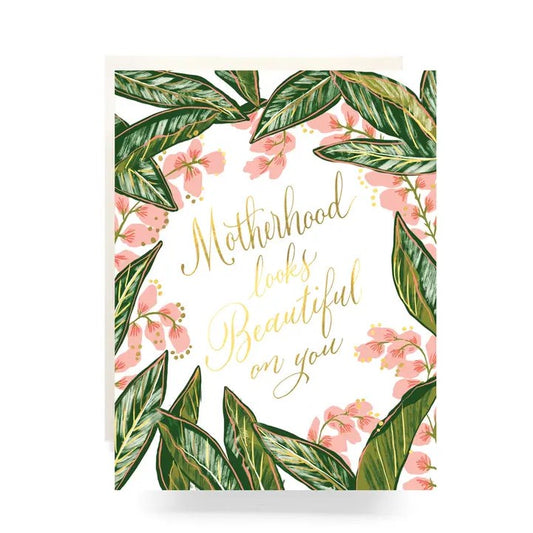 Florals surrounding the quote "Motherhood looks beautiful on you" in gold foil