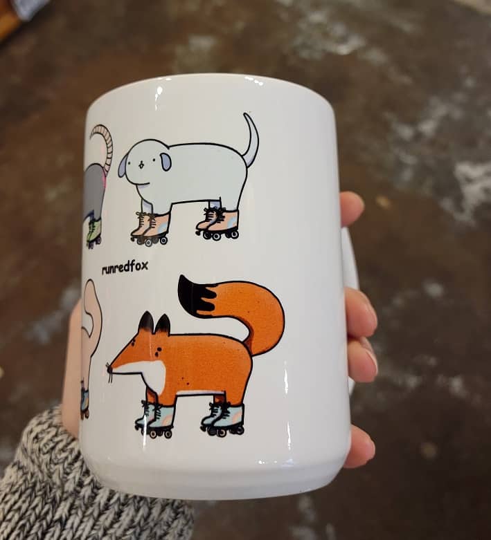 fox and dog wearing roller skates on a mug